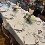 mesa mantel blanco y flores rosas y amarillas